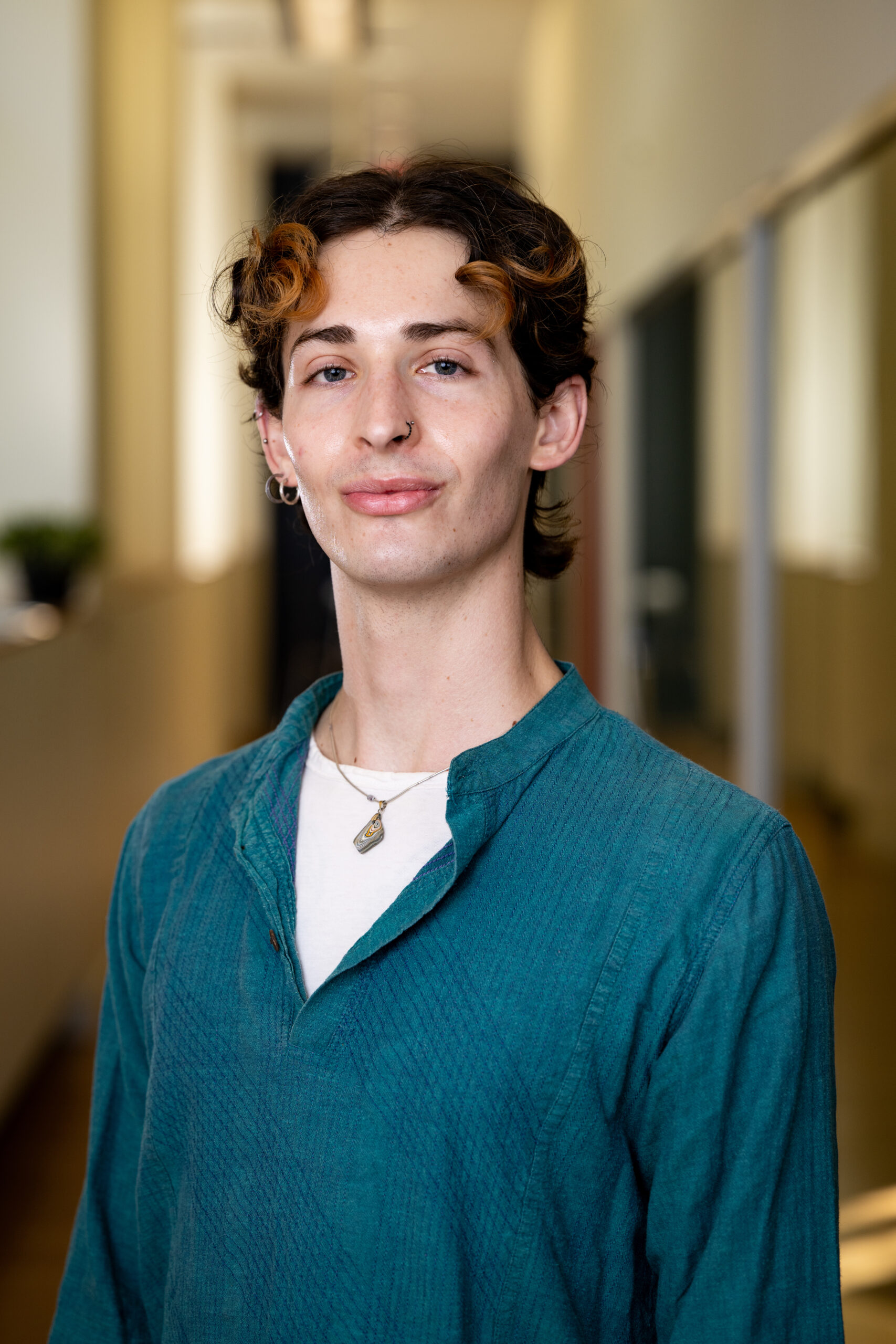 Man with wavy brown hair and teal shirt